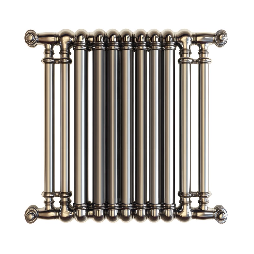 Vue d’un radiateur en fonte installé près d’une pompe à chaleur domestique.